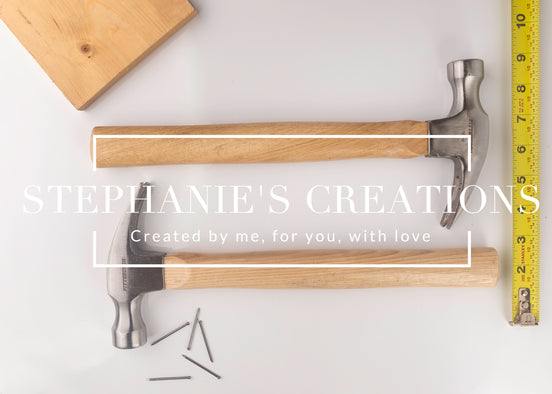 Top-down image of two wood-handled hammers with blank handles, styled with nails, tape measure, and wood board for engraving mockup use.