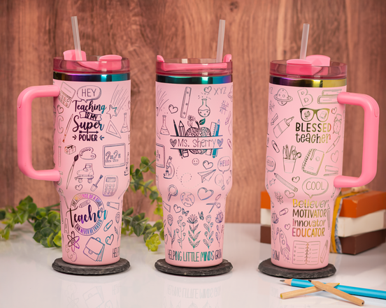 Three personalized pink teacher tumblers with engraved rainbow designs and handles