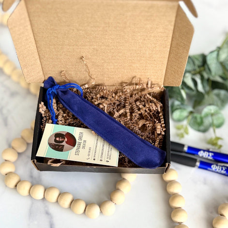 Elegant packaging featuring blue drawstring pen sleeve and Stephanie’s Creations business card