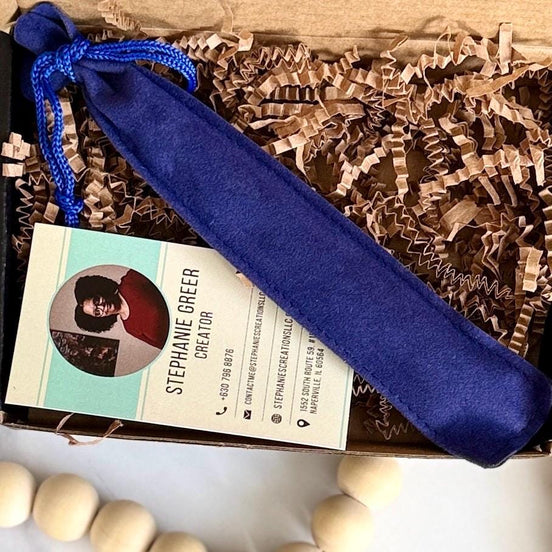 Blue velvet pouch holding a custom engraved pen displayed in eco-friendly packaging