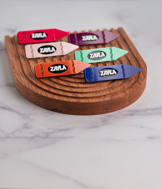 Vibrantly colored crayon-shaped hair clips, crafted with intricate laser-cut details. These playful and unique hair accessories add a touch of whimsy and style to any hairdo.
