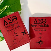 Two personalized DST laser engraved passport holders in crimson leatherette with Greek letters and travel design