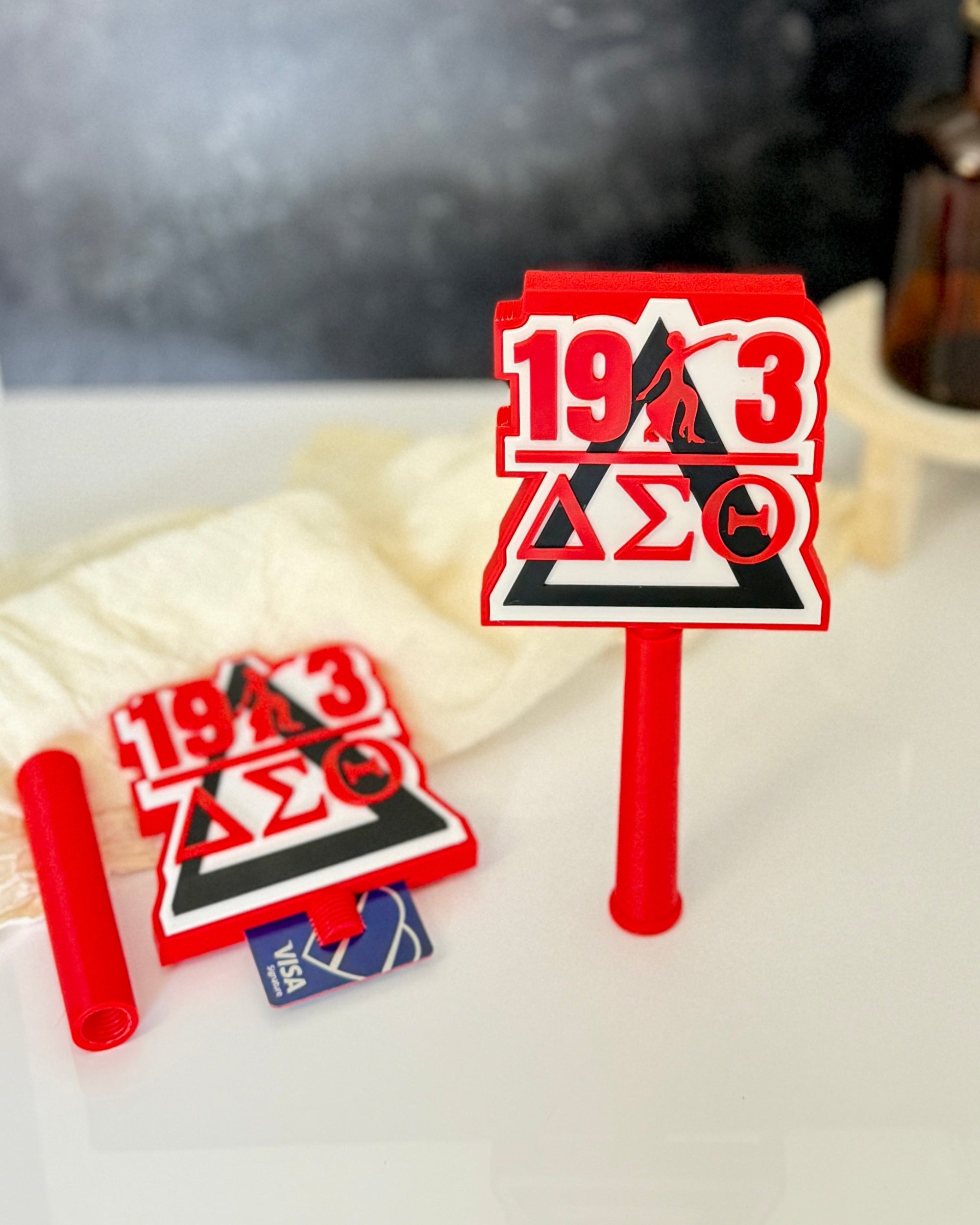 Delta Sigma Theta 3D printed tap-to-pay wand and card holder topper displayed with credit card showing card slot, licensed DST sorority gift in crimson red and black