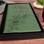 Angled view of green Notes to My Mom keepsake journal showing engraved floral artwork, script lettering, and stitched edges.