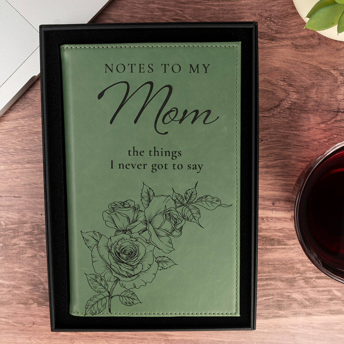 Overhead view of green Notes to My Mom engraved journal with rose artwork and the phrase the things I never got to say.
