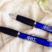 Close-up of official licensed Phi Beta Sigma engraved pens with sleek black grips