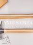 Top-down image of two wood-handled hammers with blank handles, styled with nails, tape measure, and wood board for engraving mockup use.