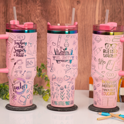 Three personalized pink teacher tumblers with engraved rainbow designs and handles